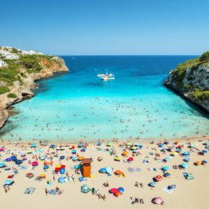 Aerial,View,Of,Colorful,Umbrellas,On,Crowded,Sandy,Beach,,Boats,